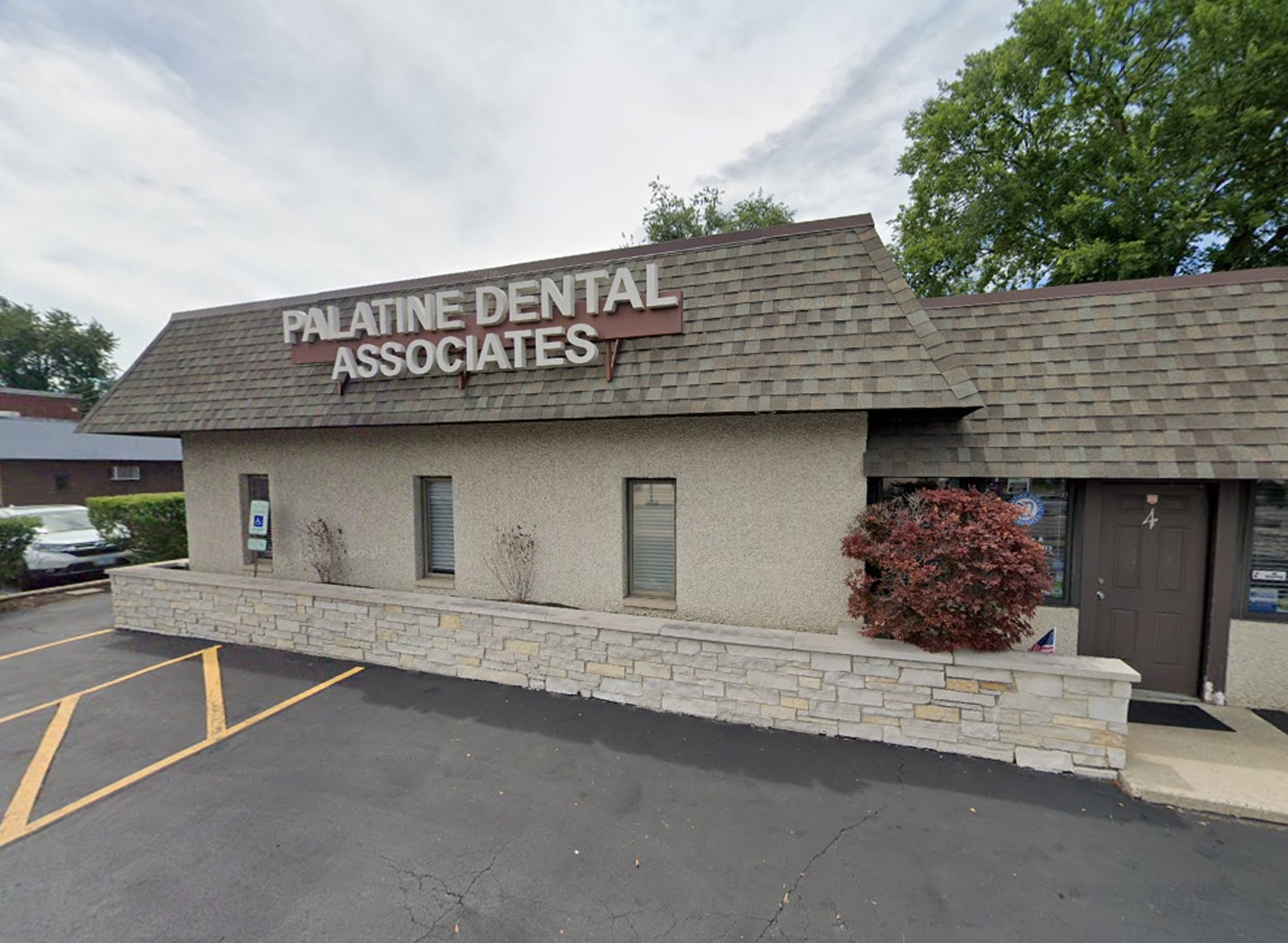 Palatine Dental Associates exterior storefront with parking lot and landscaping.