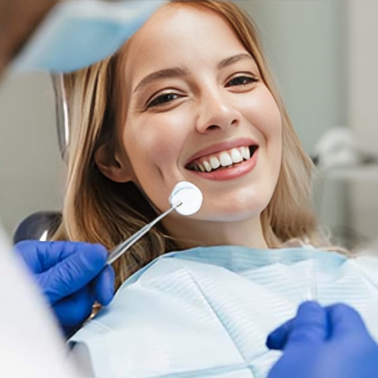 Young woman smiling during dental examination with dentist holding mirror in clinic.