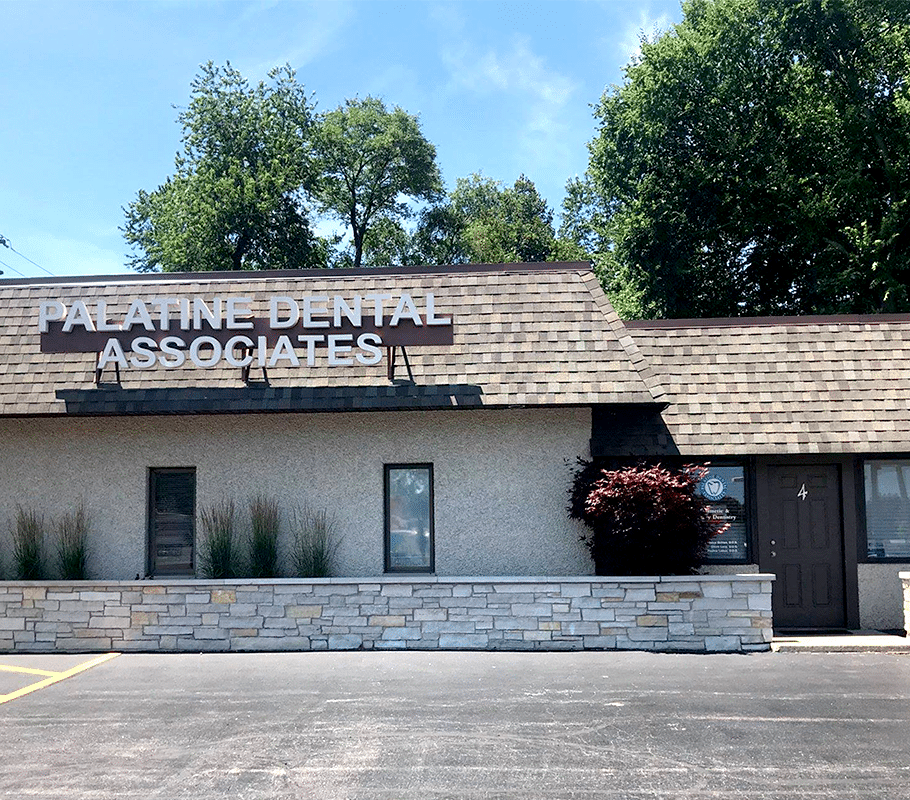 Palatine Dental Associates office building exterior with stone facade and signage on roof.