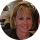 Professional headshot of a dental practice team member in clinical setting.