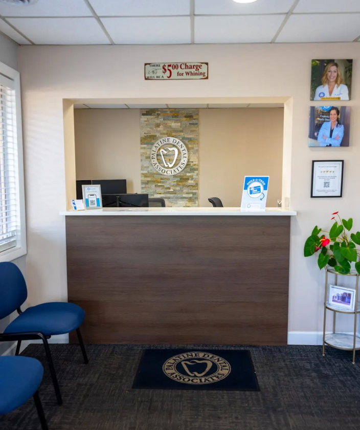 Reception desk at Palatine Dental Associates with blue waiting chairs and welcoming clinic interior